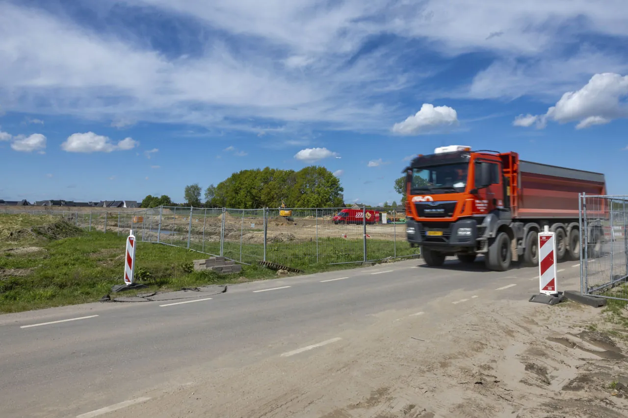 Vrachtwagen bij een bouwterrein met hekwerk