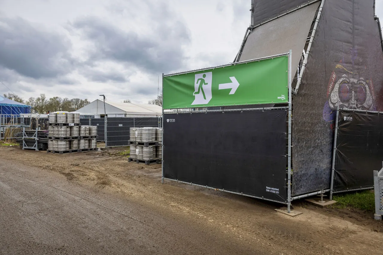 Gezeild hekwerk met nooduitgang-banner