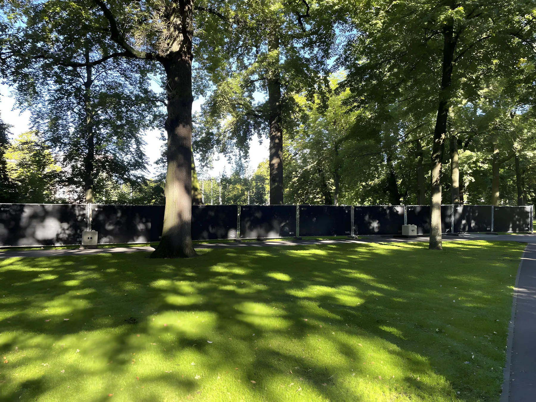 Zwart gezeild hekwerk van Freyja tussen de bomen in een park
